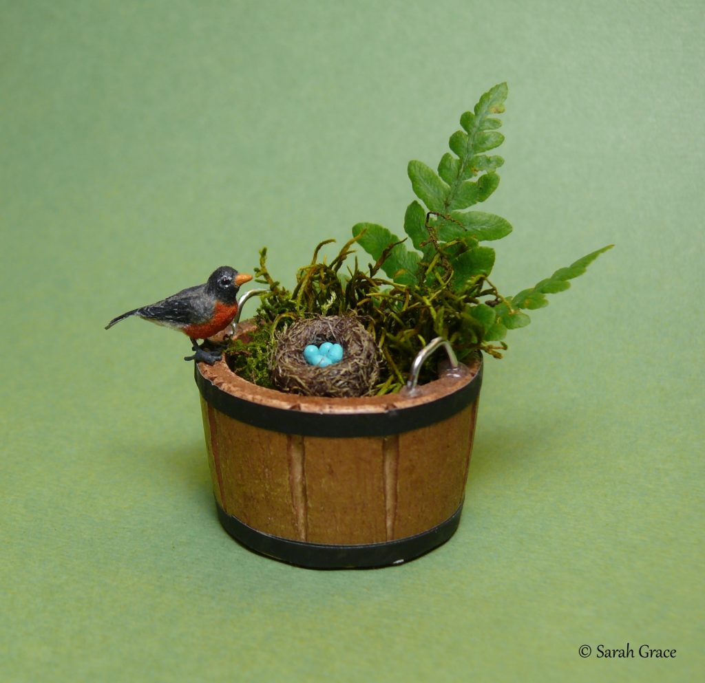 Detailed miniature American robin sculpture with nest by Sarah Grace
