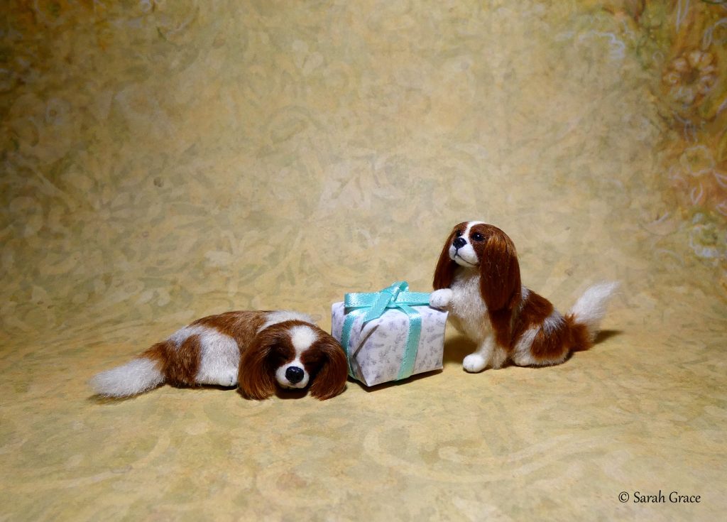 Pair of detailed miniature King Charles Cavalier Spaniel sculptures posed together with realistic fur textures by Sarah Grace