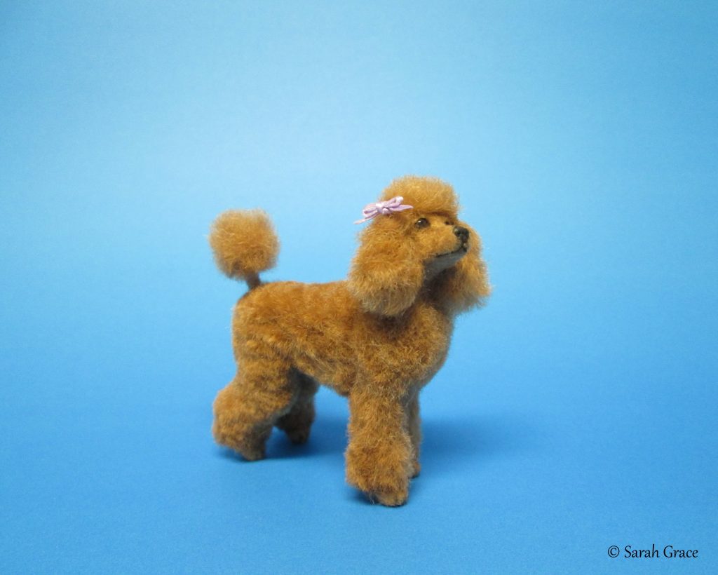 Elegant handmade miniature poodle dog sculpture in a classic groomed pose with curly fur details by Sarah Grace